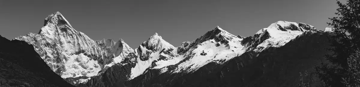 A panoramic black-and-white view of snow peaks in Siguniang Mountain.