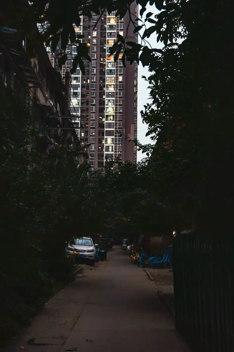 A high-rise seen through a dark alley.