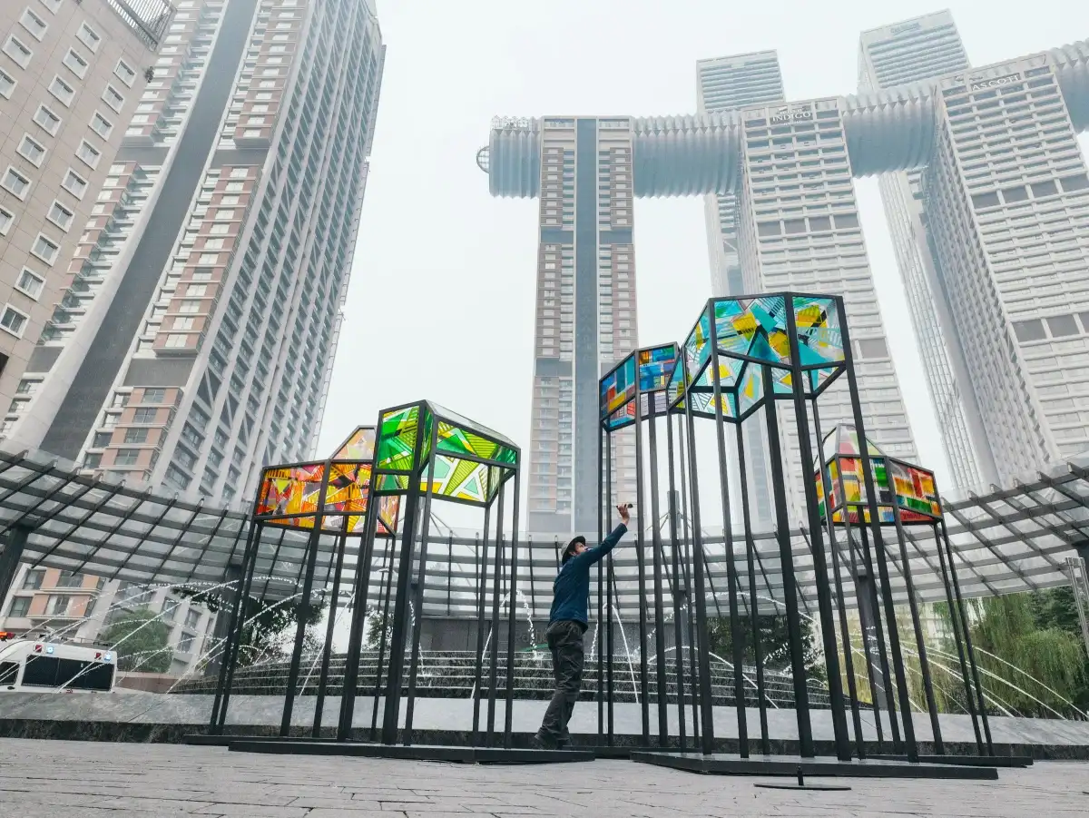 A wide public installation framed by towers.