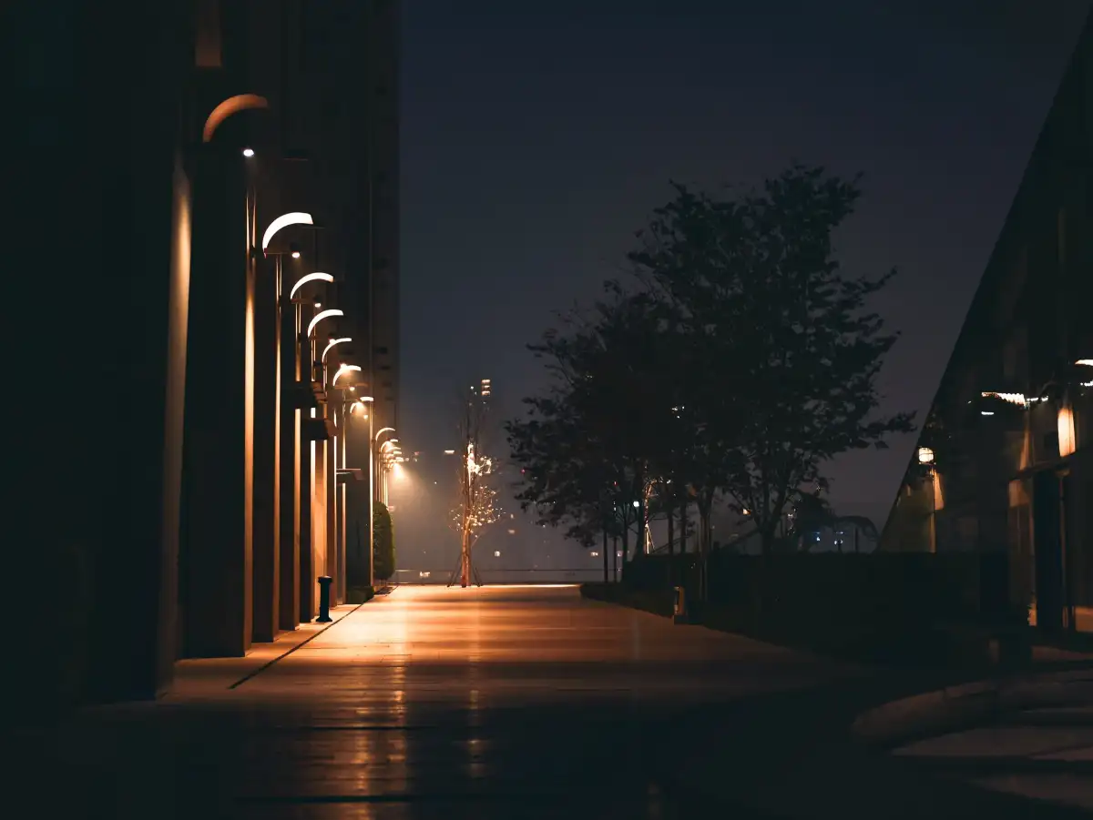 A quiet corridor lit by lamps at night.