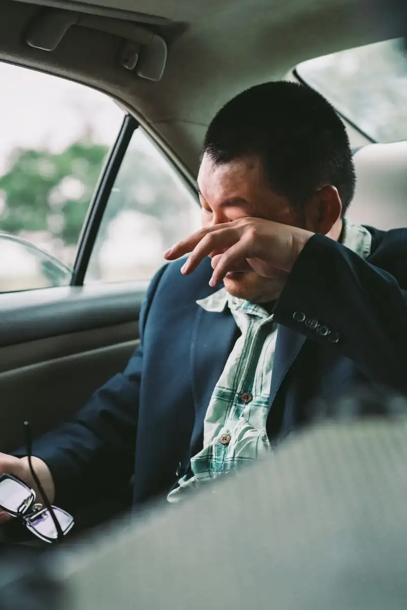A portrait of a man inside a car.