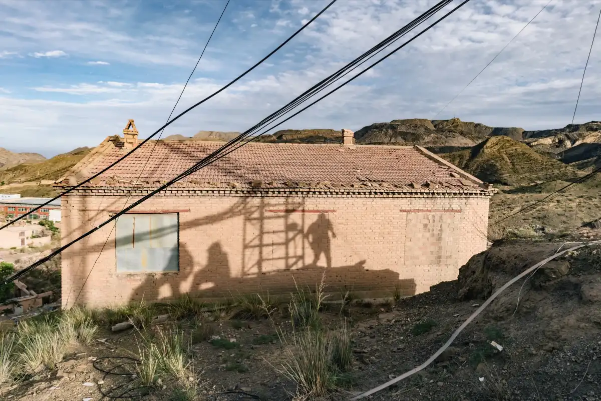Shadows and cables falling across a rural house.