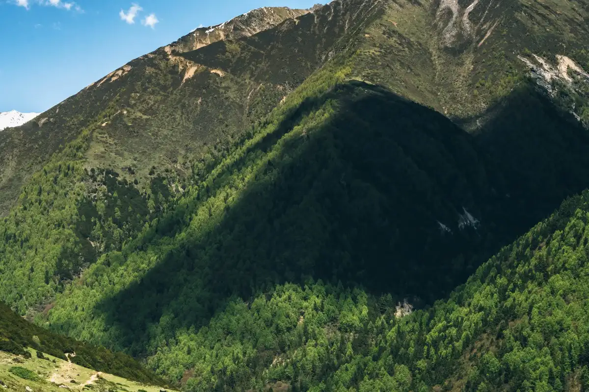 A mountain ridge crossed by a large shadow.