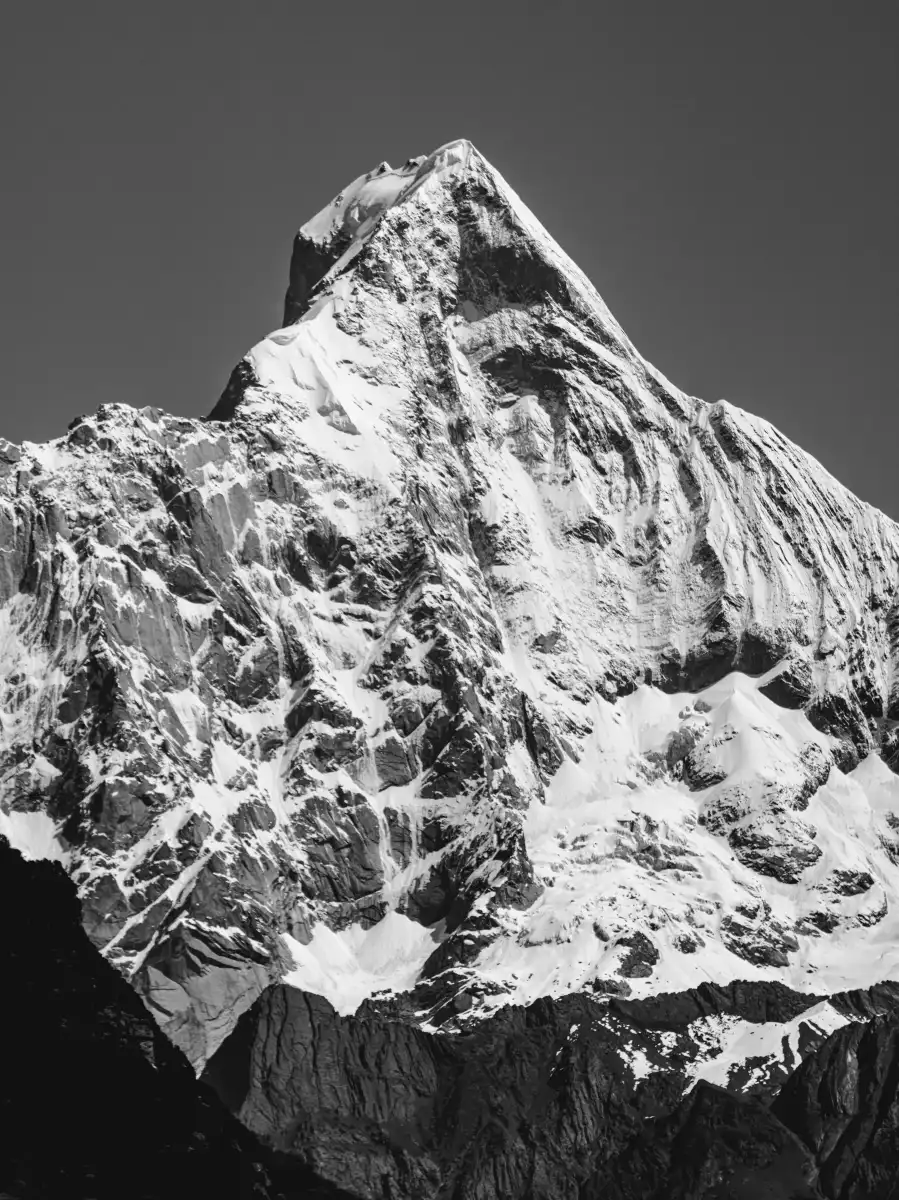 A steep black-and-white mountain face rising against the sky.